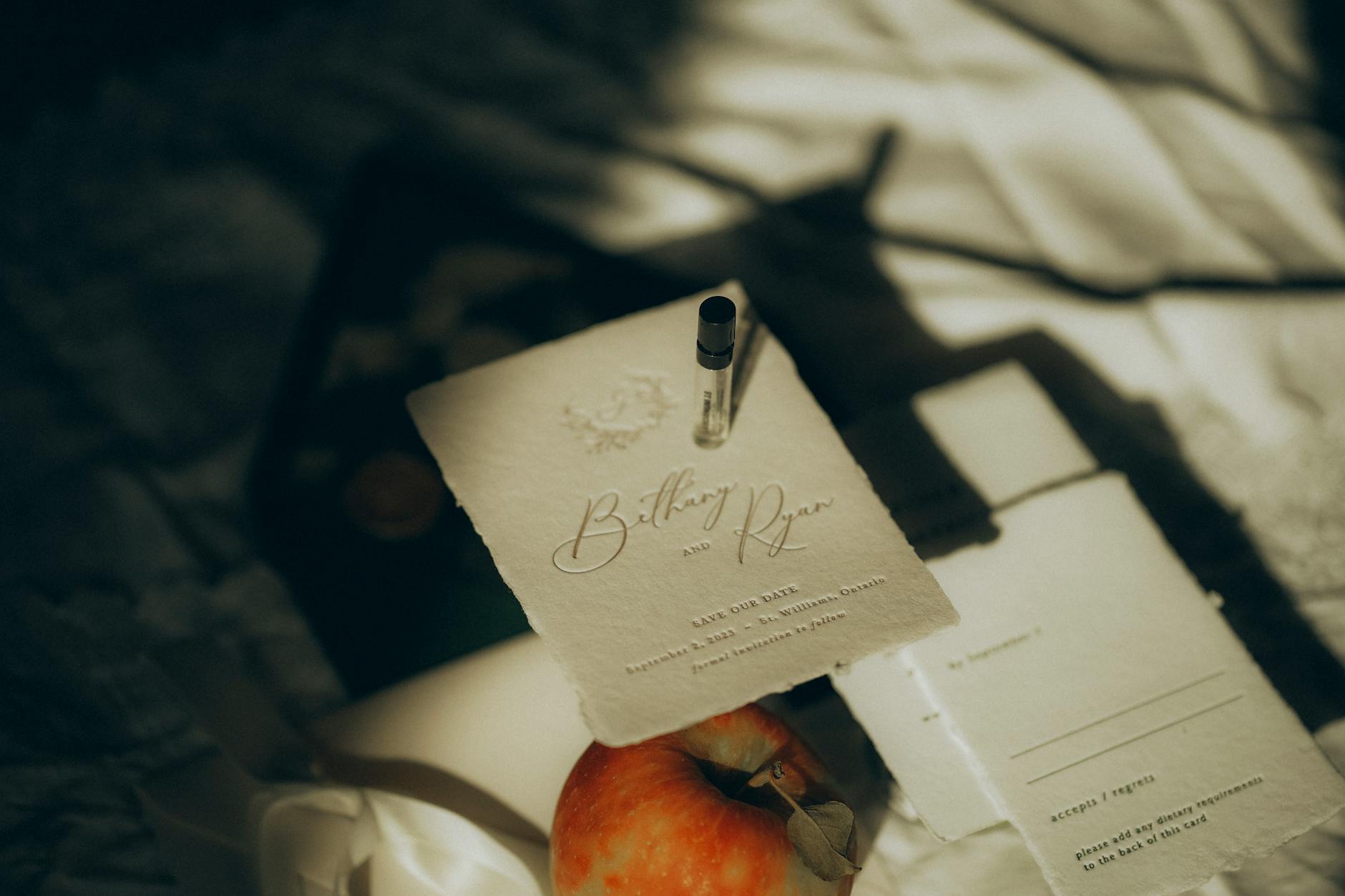 Minimalistyczne zaproszenie ślubne z jabłkiem i flakonikiem perfum