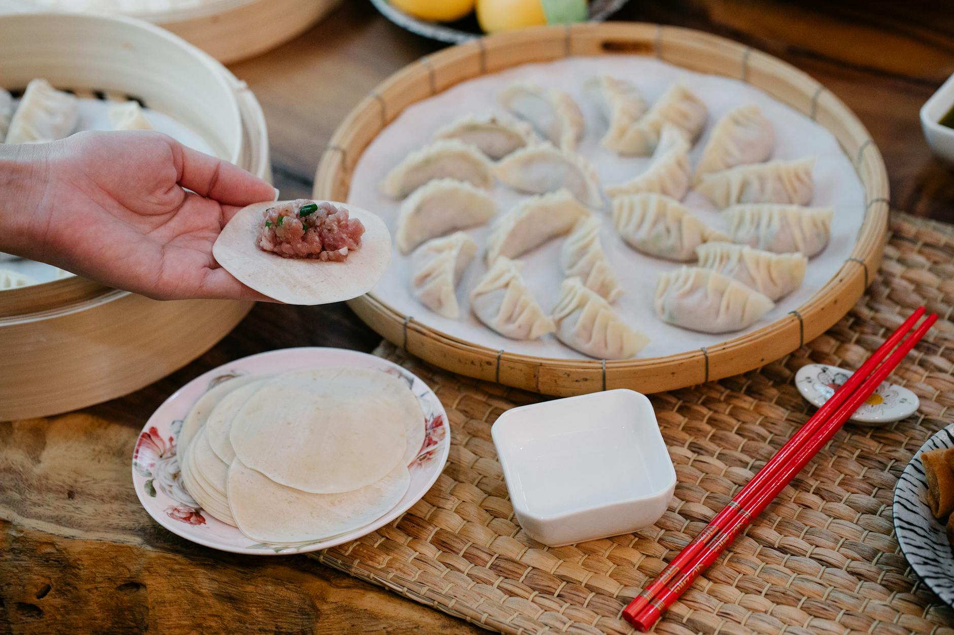Lepienie domowych pierogów z mięsem na kuchennym blacie