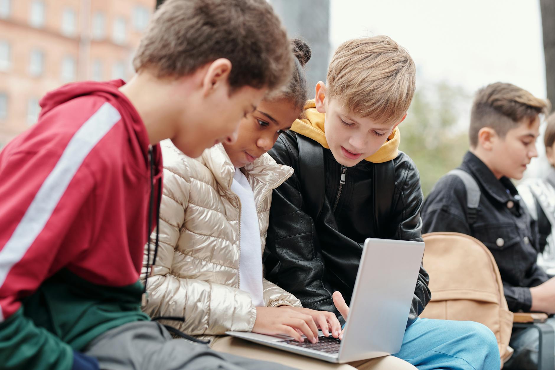 Nastolatki uczą się wspólnie na laptopie w plenerze