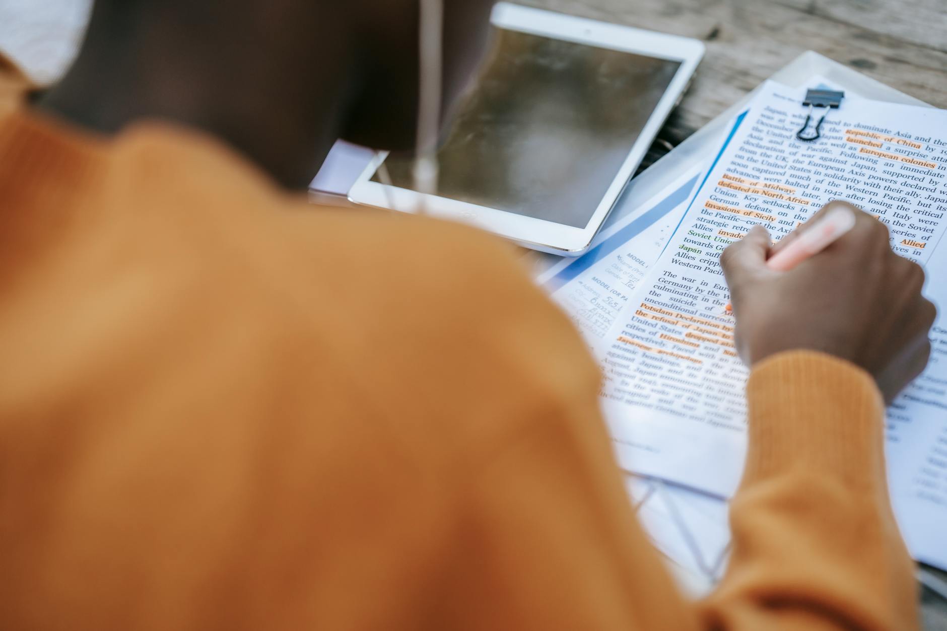 Uczeń podkreśla tekst przy tablecie na biurku