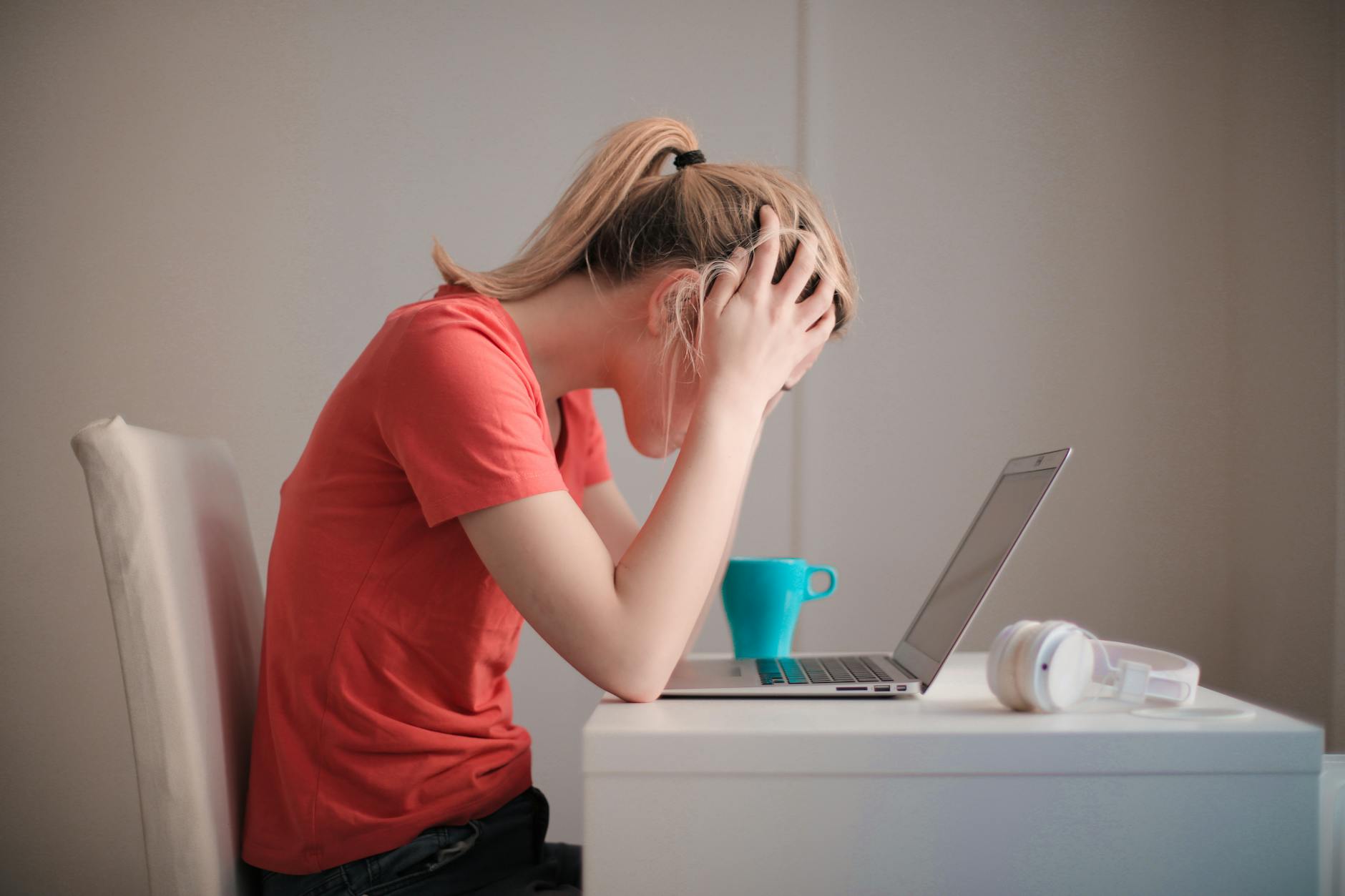 Zestresowana studentka przy laptopie i kawie uczy się w domu