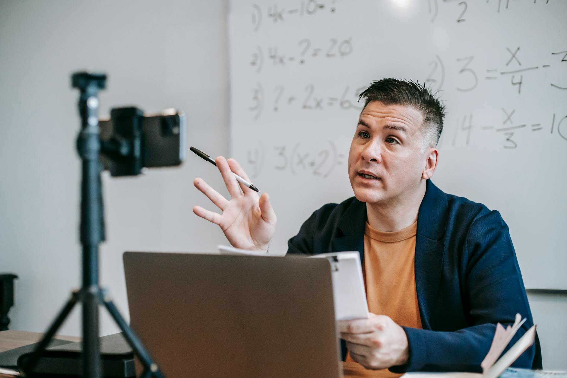 Nauczyciel matematyki prowadzi lekcję online przez laptop i kamerkę