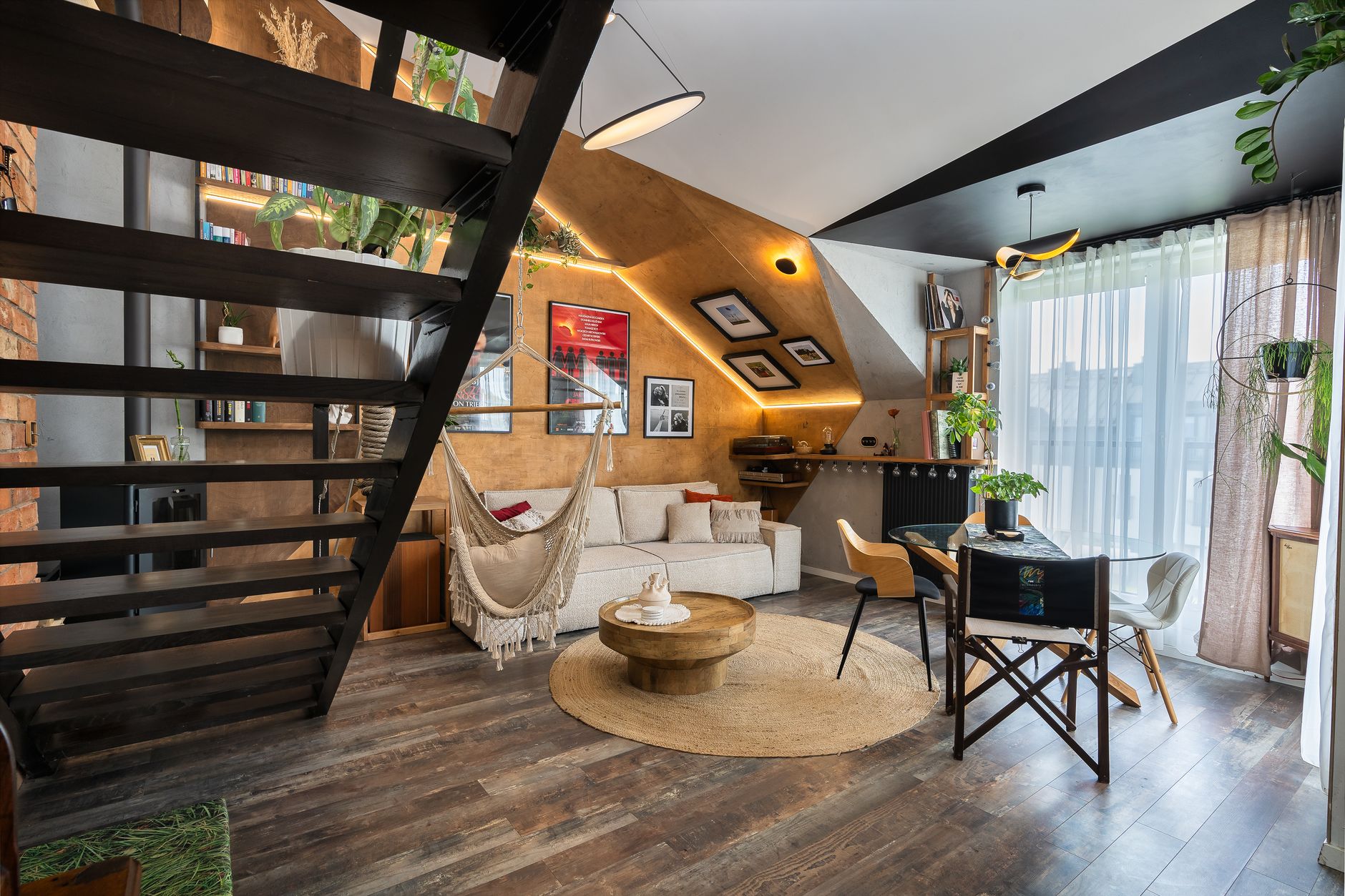 Nowoczesny loft w praktyce – jak zaprojektować funkcjonalne i przytulne wnętrze Nowoczesny salon w lofcie z hamakiem, schodami i dużą ilością światła