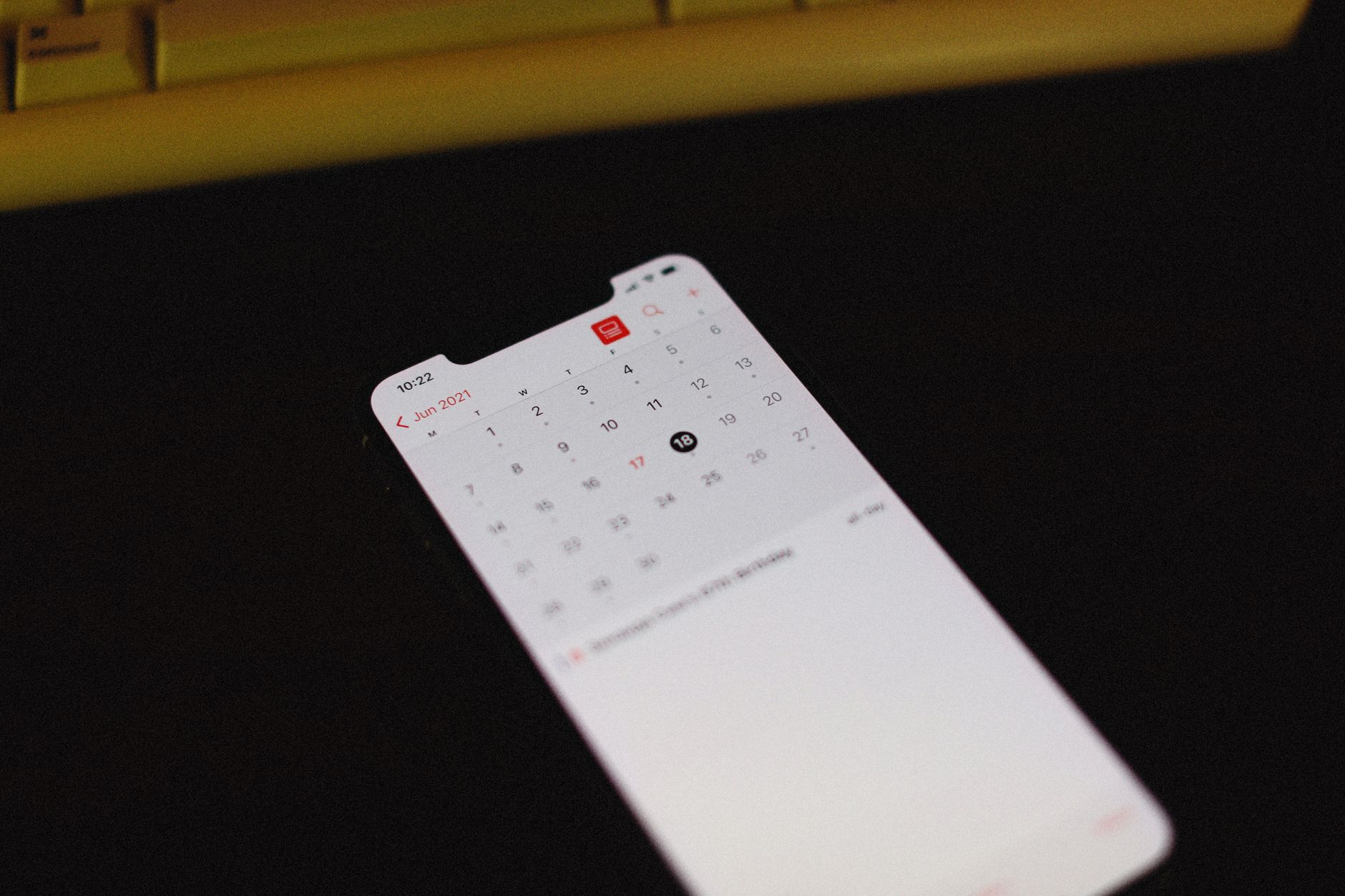 Plan dnia ucznia z wykorzystaniem aplikacji mobilnych do organizacji czasu Smartfon z otwartą aplikacją kalendarza na ciemnym tle