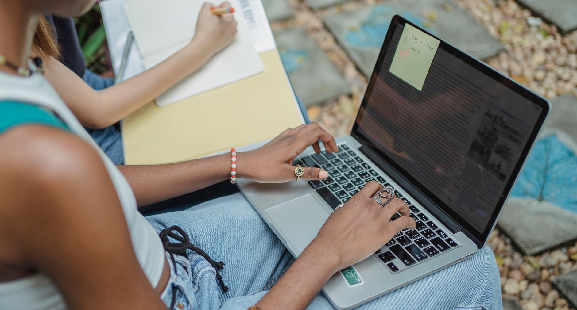 Microsoft Word dla uczniów: 7 trików, które przyspieszą pisanie Uczennice w parku piszą na laptopie i robią notatki do zadania