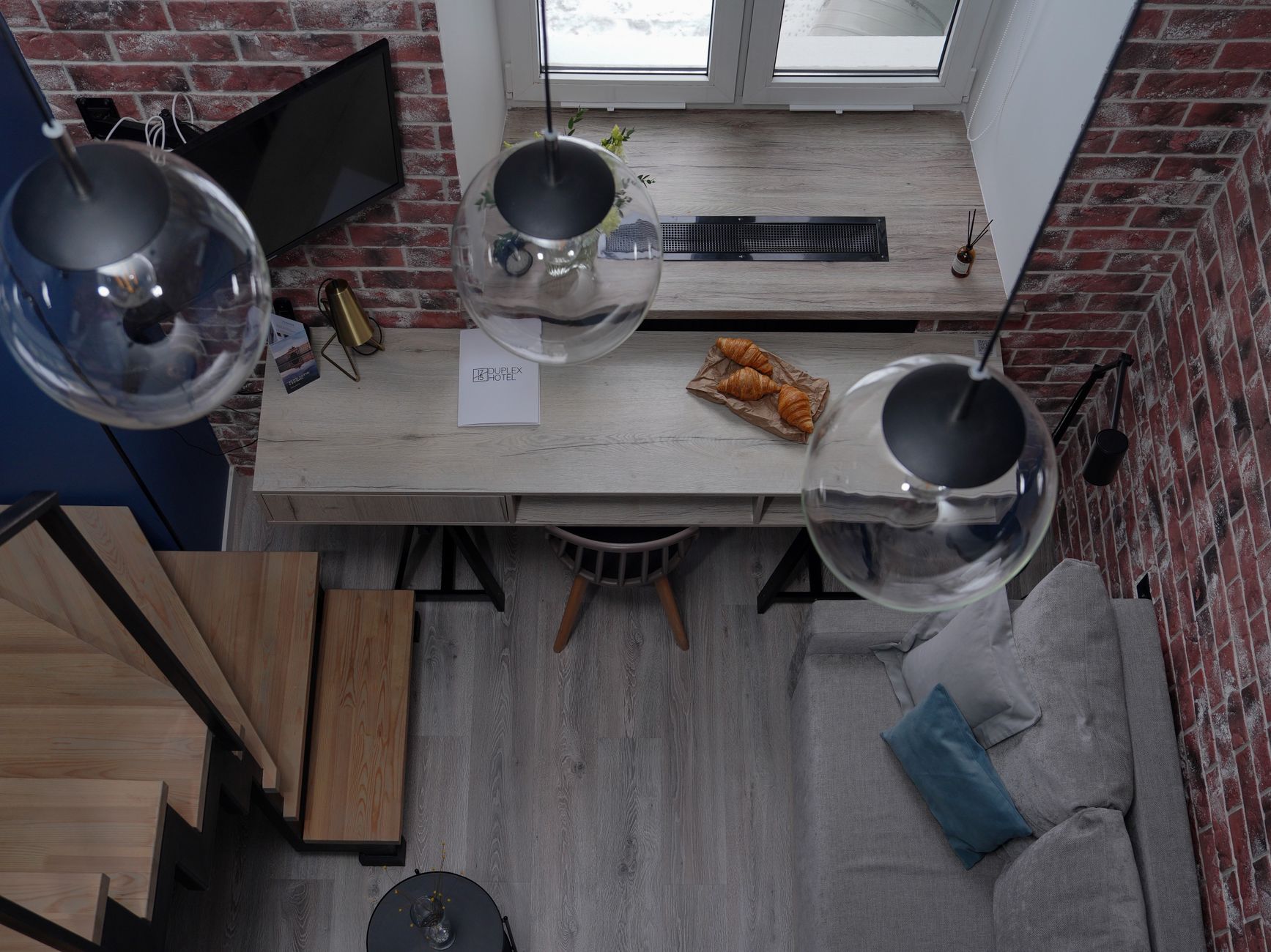 Widok z góry na nowoczesny loft z croissantami i designerskim oświetleniem