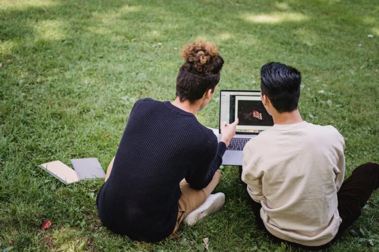 Uczniowie pracujący na netbooku podczas nauki w parku